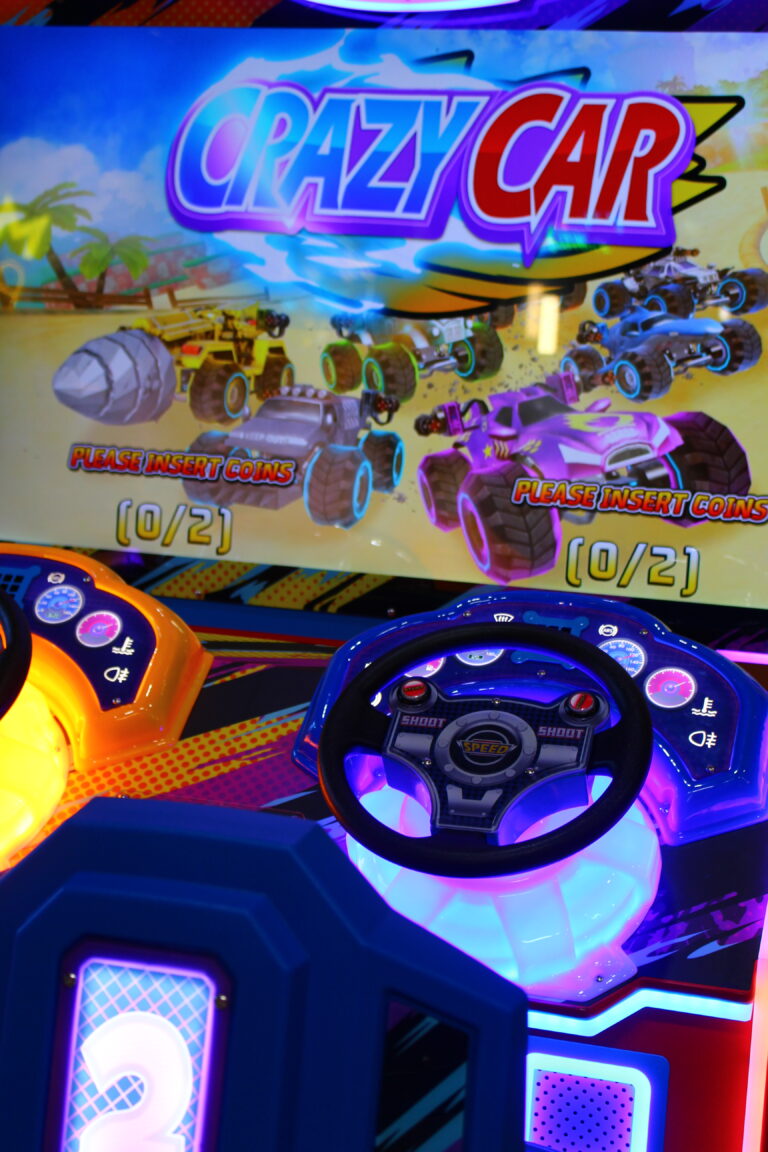 Ein Spielautomat mit zwei Lenkrädern, bei welchem vorne ein Bildschirm ist.